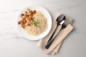 Delicious rice with parsley and mushrooms served on white marble table, flat lay
