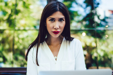  Latino woman with modern laptop computer