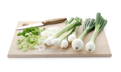 Wooden board with knife, whole and cut spring onions isolated on white