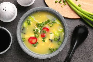 Bowl of delicious miso soup with tofu served on grey table, flat lay