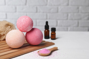 Beautiful composition with aromatic bath bombs on white table, space for text