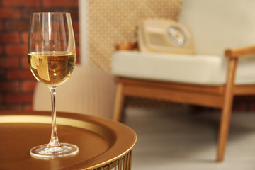 Glass of white wine on table in room, space for text. Relax at home