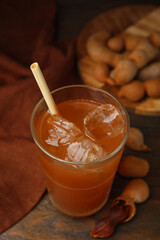 Freshly made tamarind juice and fresh fruits on wooden table, above view