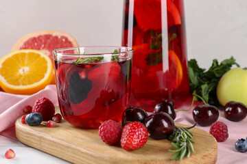 Glass of delicious sangria, fruits and berries on table, closeup