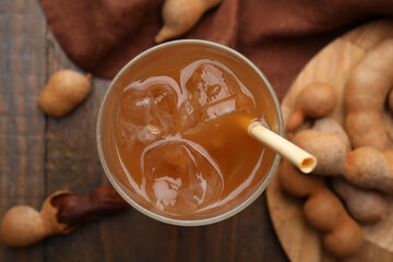 Tamarind juice and fresh fruits on wooden table, flat lay