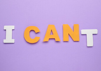 Motivation concept. Changing phrase from I Can't into I Can by removing paper letter T on violet background, top view