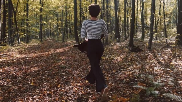mom with her son in the garden with there dog sitting and playing near the trees