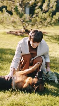 mom with her son in the garden with there dog sitting and playing near the trees