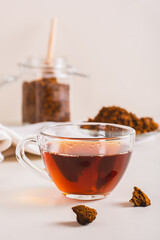 Chaga therapeutic tea from birch mushroom in a cup on the table vertical view