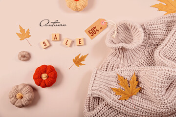 Flat lay composition for seasonal autumn sale with knitted sweater, crochet pumpkins, dry leaves...