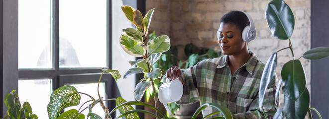 Concept of mental health, hobbies, do favourite things on leisure time. African American woman doing home gardening, repotting plants, taking care about flowers. Domestic life, interior design banner