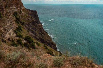 Top view of blue sea water with white waves and stones. Seascape. Clean clear sea water. Abstraction. Minimalism. There are no people in the photo. There is free space to insert.