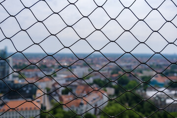 Fototapeta premium Zaun mit Stadt im unscharfen Hintergrund