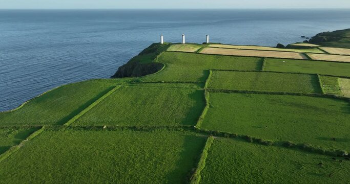 White lighthouses stand at the end of the mainland