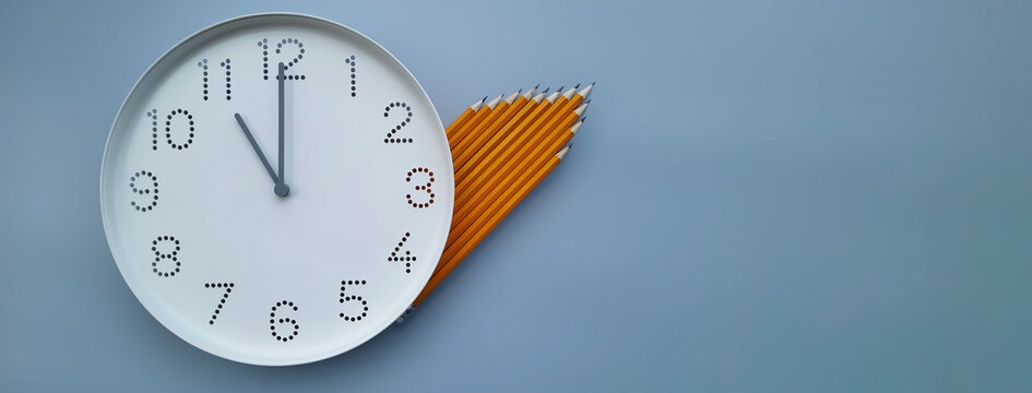 Banner with clock. 11 o'clock. Study time. Back to school. Watch with white clock face on blue table background with pencils. Copy space. Concept of study, deadline, schedule. Header for website, blog