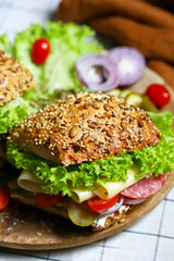 Salami sandwiches with pickles and lettuce.