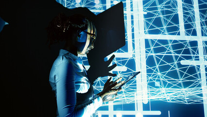 Licensed worker programming in AI server farm housing advanced equipment used for machine learning training. Trained engineer running code on tablet to upgrade artificial intelligence rigs