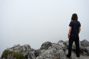 Einsamer Wanderer auf Berggipfel bei Nebel - obrazy, fototapety, plakaty
