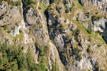 Nahaufnahme einer Felswand mit Wanderern im Klettersteig