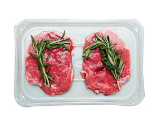 Two boneless lamb leg steaks on a plastic tray and rosemary green spicy herb. Uncooked high quality meat product with rich taste and vivid color.