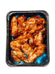 Raw uncooked marinated chicken wings in black plastic tray. High quality poultry product with delicate rich flavor. Food supply chain.