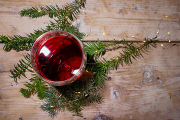 A glass of red wine on a wooden background, a Christmas tree