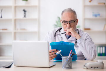 Obraz premium Old male doctor working in the clinic