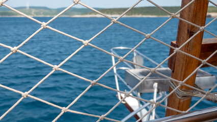 Close-up of the net on a yacht with blue sea in the background