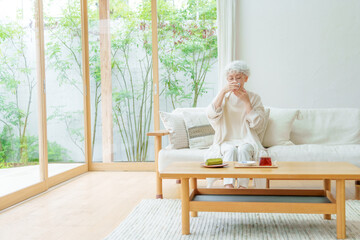 リビングでお茶を飲むシニア女性