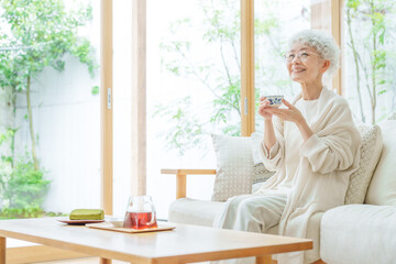 リビングでお茶を飲むシニア女性