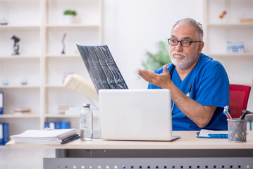 Old male doctor radiologist working in the clinic
