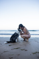 girl and her dog playing on the beach