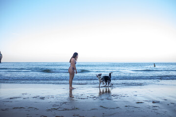 girl and her dog playing on the beach