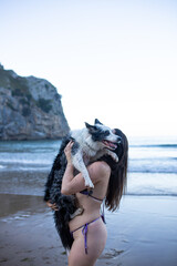 girl and her dog playing on the beach