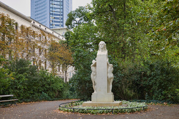 Das Friedrich-Schiller-Denkmal in einer Parkanlage vor der Kulisse des City-Hochhauses in Leipzig, Sachsen, Deutschland
