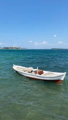 Naklejka na ściany i meble Fishing boat on the azure sea at sunny summer day.