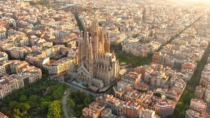 Aerial view of Barcelona city skyline and Sagrada Familia Cathedral at sunrise. Eixample residential famous urban grid. Cityscape with typical urban octagon blocks
