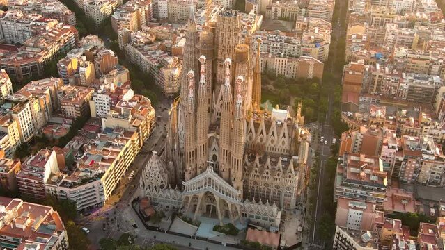 Aerial view of Barcelona City Skyline and Sagrada Familia Cathedral. Flying around the architectural masterpiece of Gaudi at sunrise golden hour