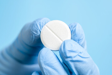 White effervescent or carbon tablet in hand in disposal glove. Doctor, pharmacist or scientist...
