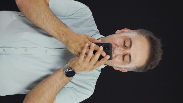 Vertical video of The man who happily puts the phone to his heart.