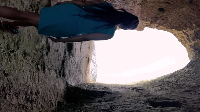 vertical video of a girl in the Anzio cave with the light at the bottom