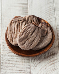 Dried persimmon on a wooden plate. The concept of dried fruits, a healthy snack
