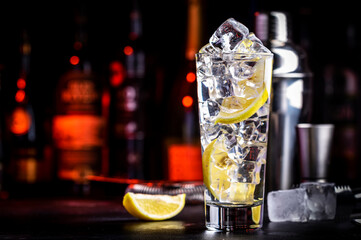 Vodka tonic transparent cocktail drink with cold vodka, lemon juice, tonic and ice cubes. Black...