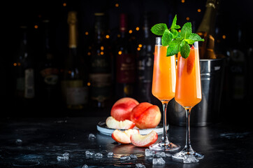 Peach Bellini classic cocktail drink with sparkling wine and peach puree, syrup and ice, dark bar...
