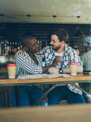 Multiracial couple admiring each other in cafe