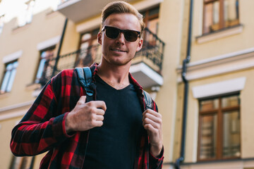 Happy confident tourist on street in sunny day