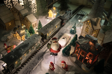 Miniature of winter scene with Christmas houses, train station, trees, covered in snow. Nights scene. New year or Christmas concept.