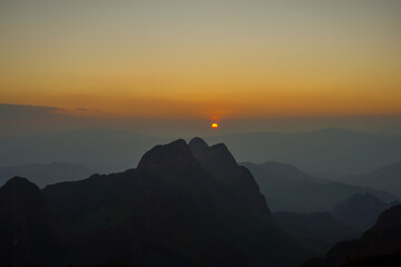 Beautiful landscape in the mountains at sunrise. View of foggy hills covered by forest.