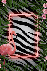 Creative composition made of tropical leaf and pink flamingos with neon light on wall background...