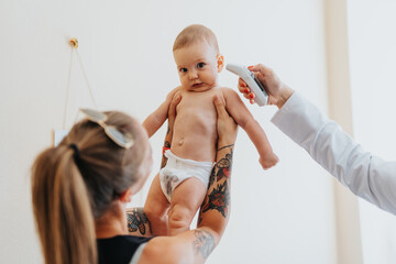 A cute baby and parent visit a caring pediatrician for a thorough examination and treatment. - obrazy, fototapety, plakaty